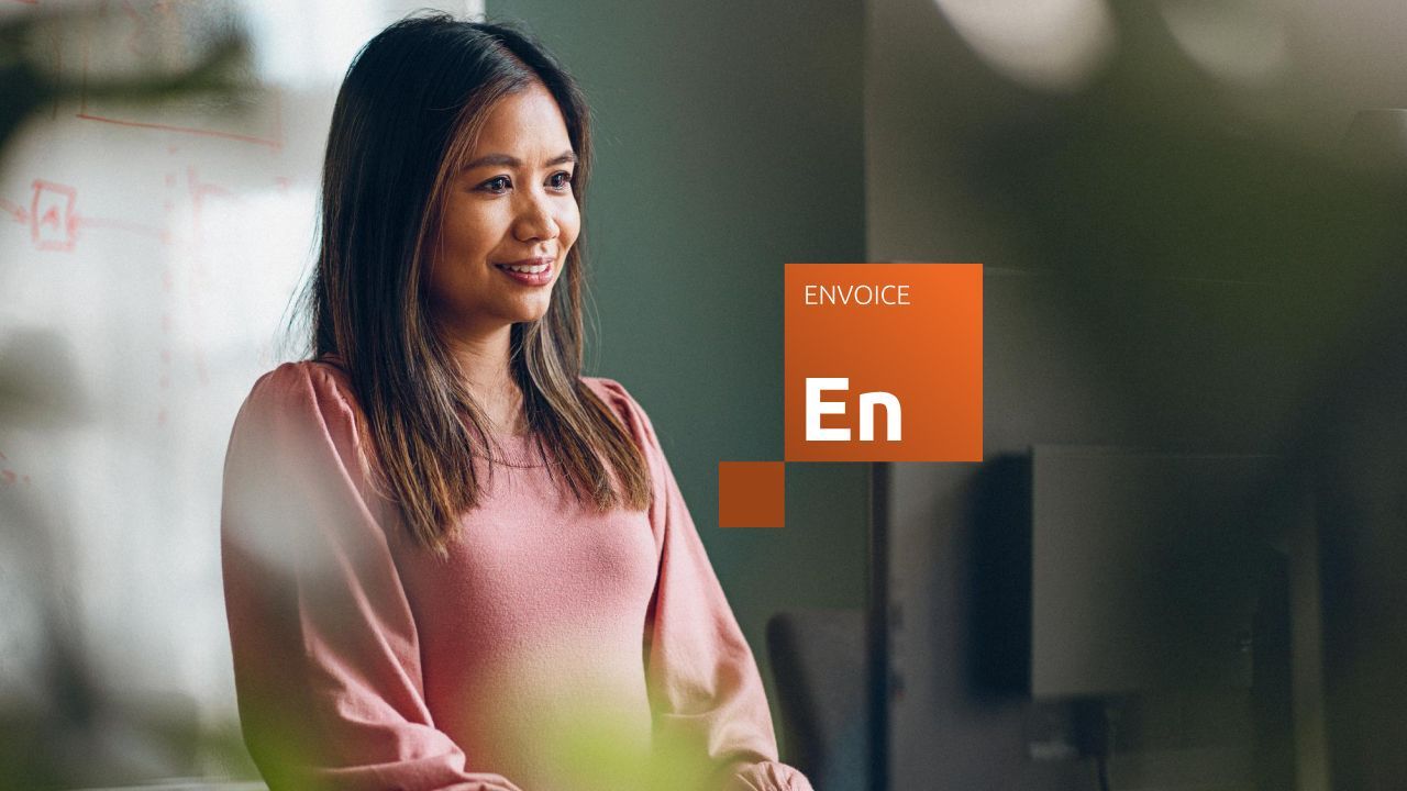 Sieviete smaida, pie darba galda.