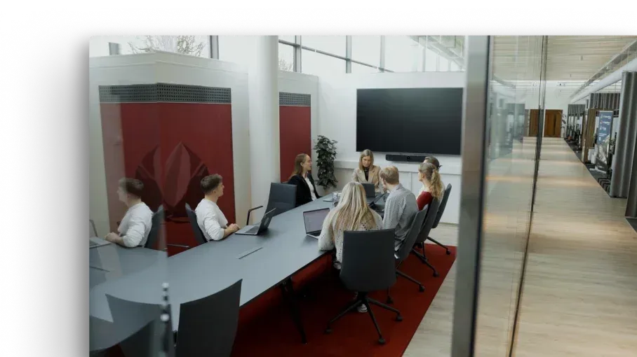 Komanda sapulcē modernā konferenču telpā.