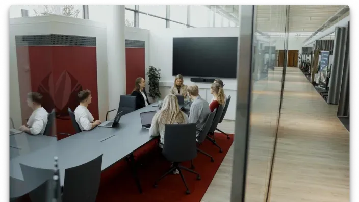 Komanda sapulcē modernā konferenču telpā.